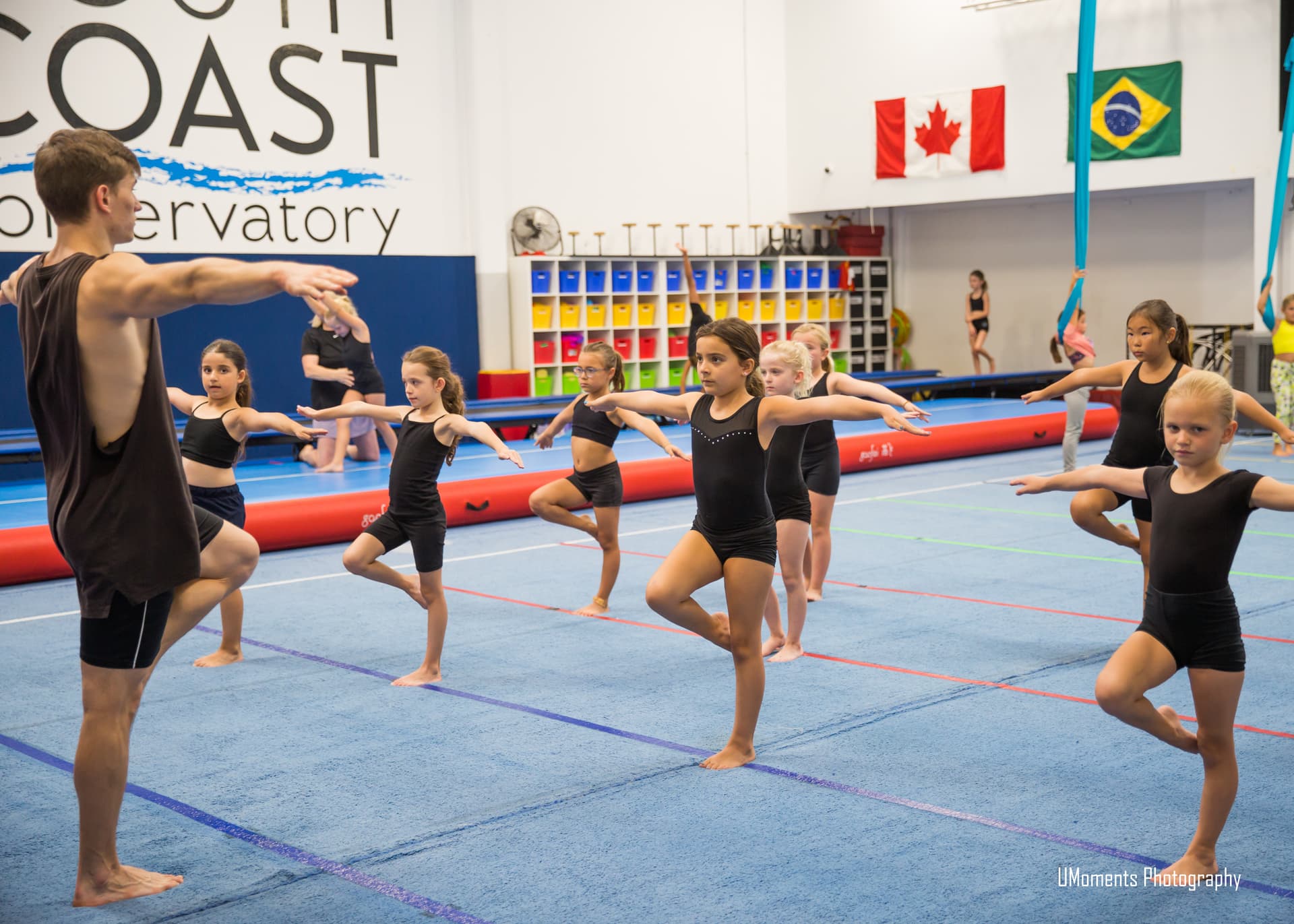 An SCC instructor leads young acro students through a balance exercise
